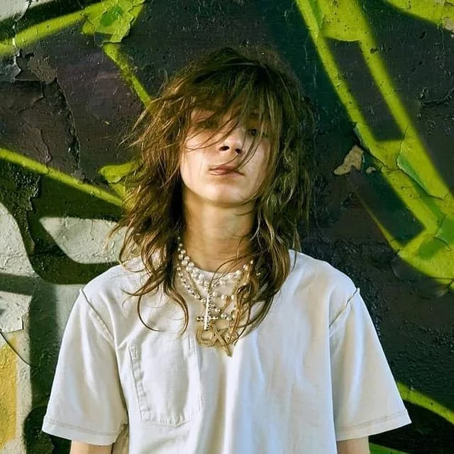 Matt Ox photographed against a graffiti wall